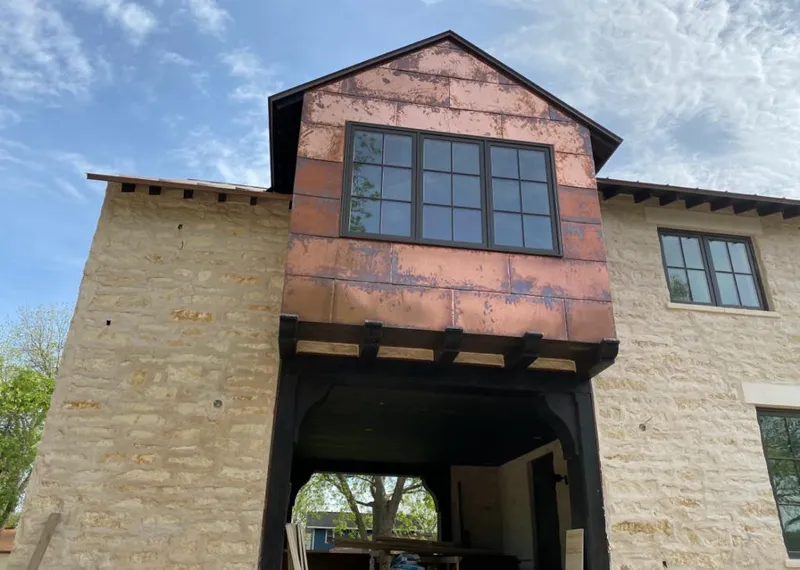 Copper metal panel facade on a stone building for Skylight Installation in Waupaca