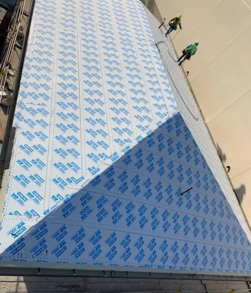 Professional roofers installing underlayment on a metal roof in Waupaca